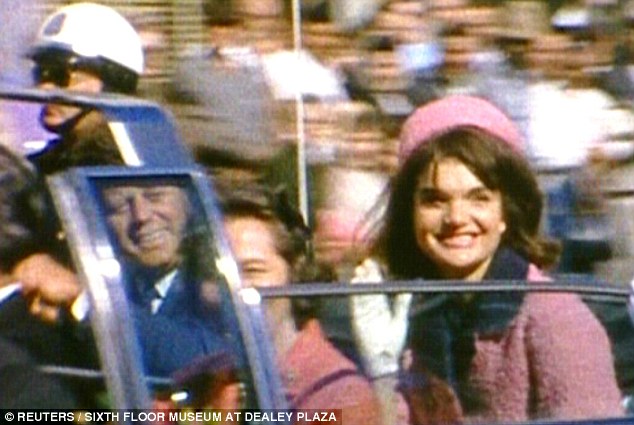 Jacqueline Kennedy in pink suit and pillbox hat, riding with JFK in limo in Dallas on November 22, 1963.