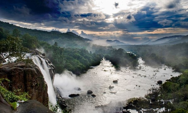 Kerala, India, waterfall and green mountains during monsoon rainy season.