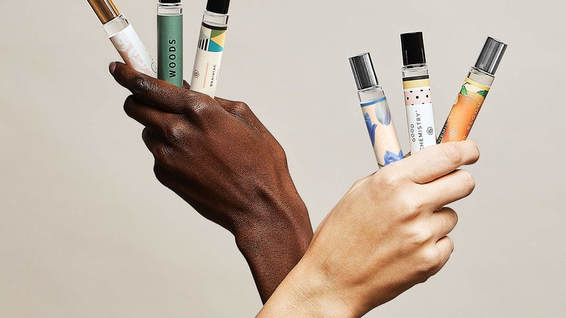 Hands holding rollerballs of Target Good Chemistry fragrance collection