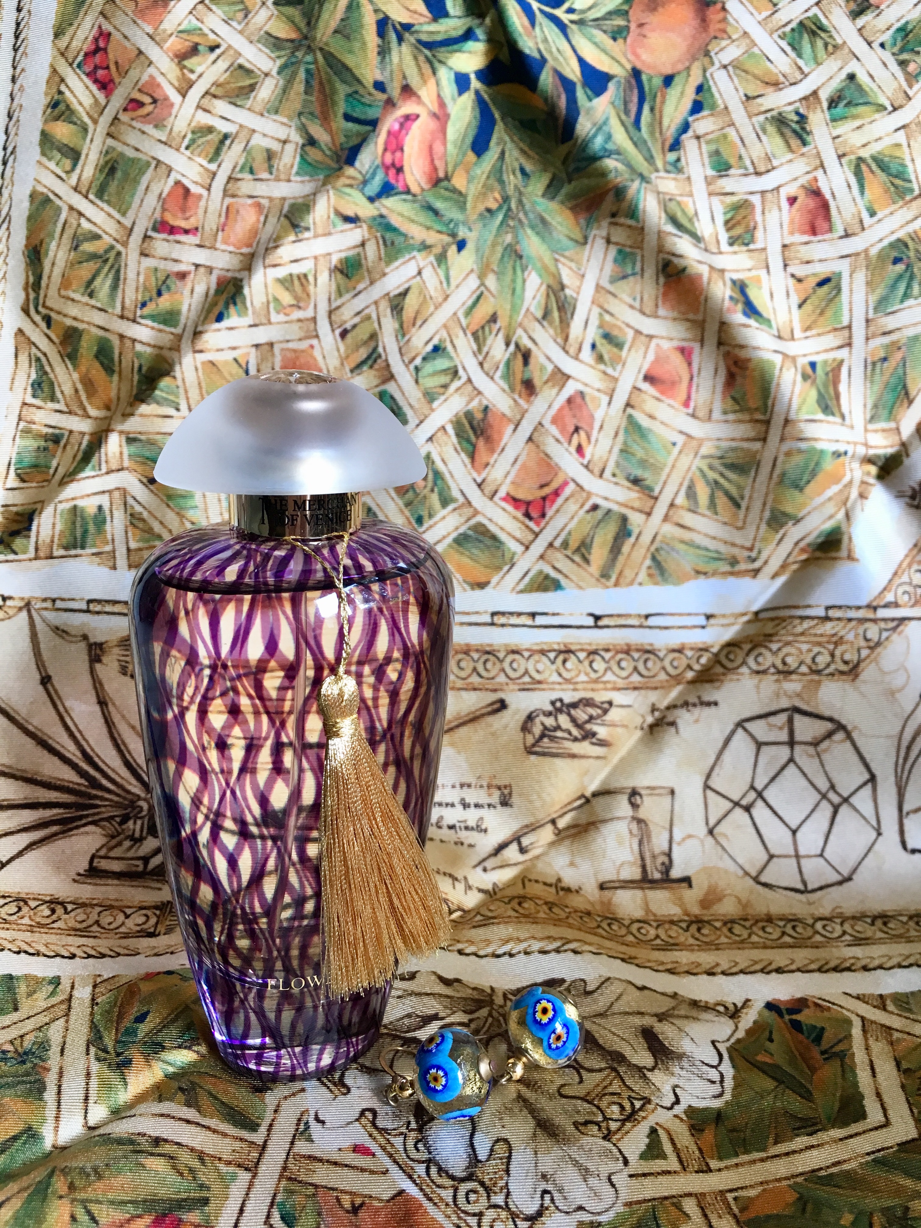 Bottle of Merchant of Venice fragrance Flower Fusion with Murano glass earrings and Massimo Ravinale scarf based on Leonardo da Vinci