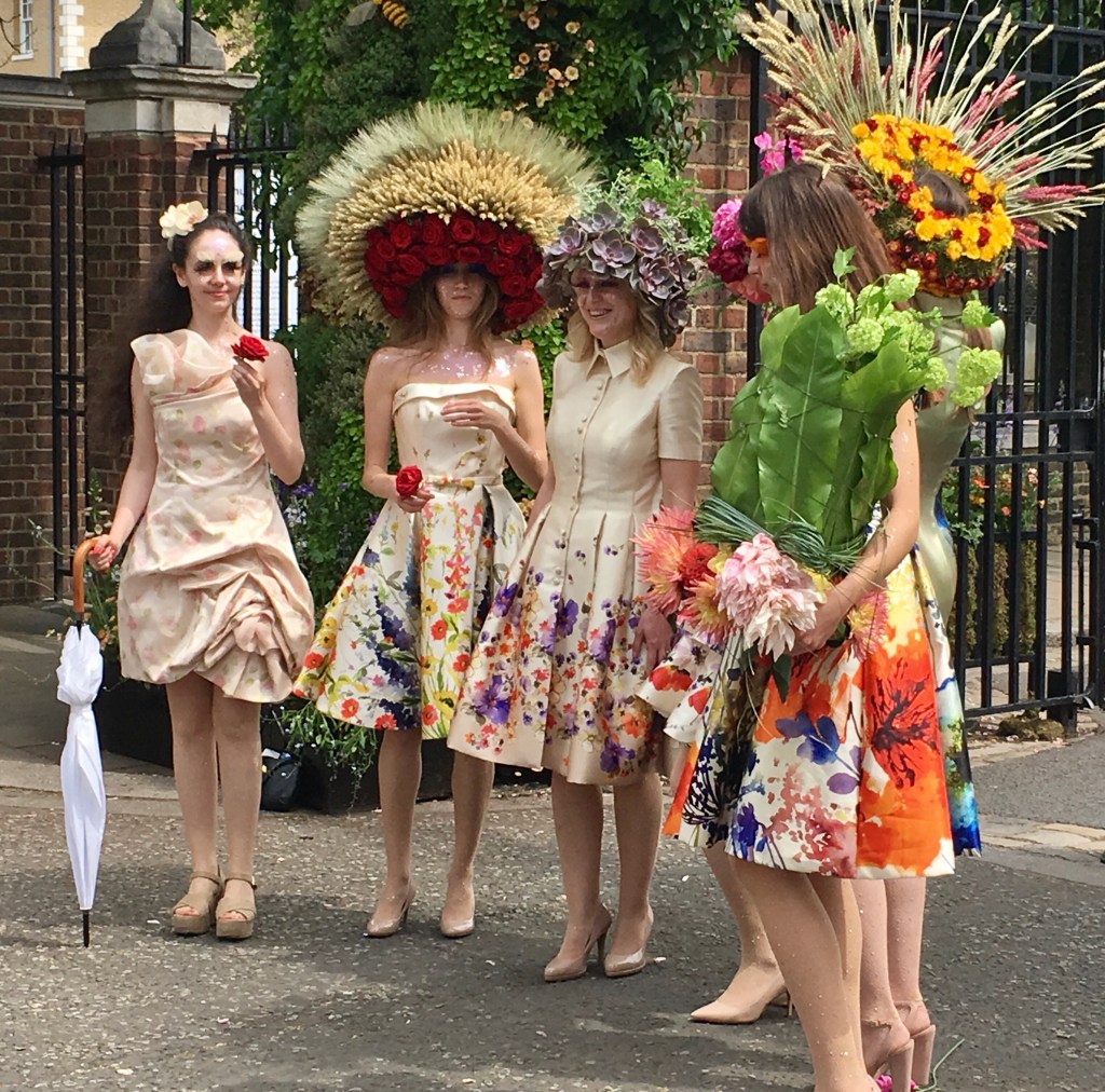 Singers with giant flower hats and flowered dresses at RHS Chelsea Flower Show.