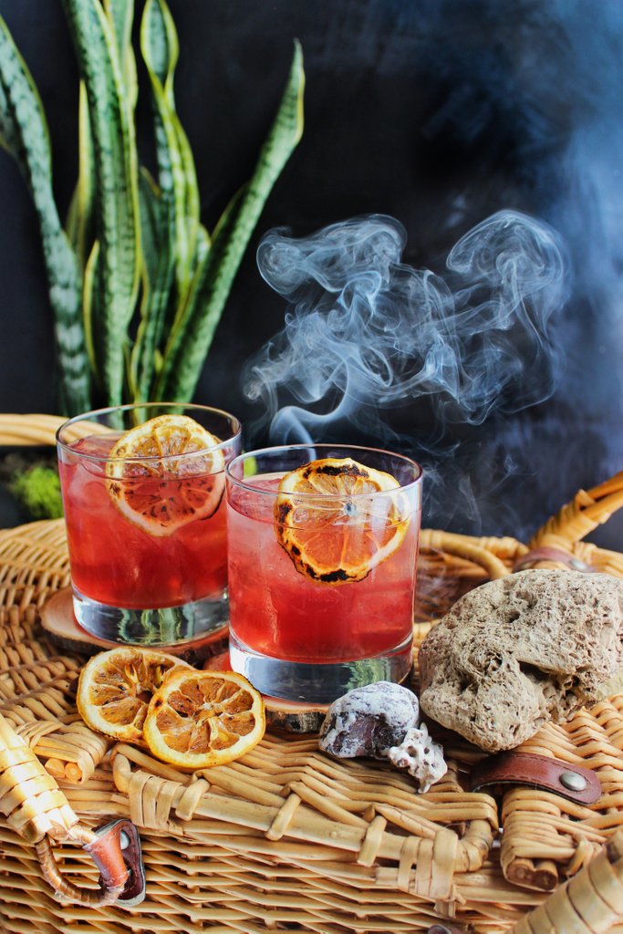 Cocktail glasses with charred citrus garnish
